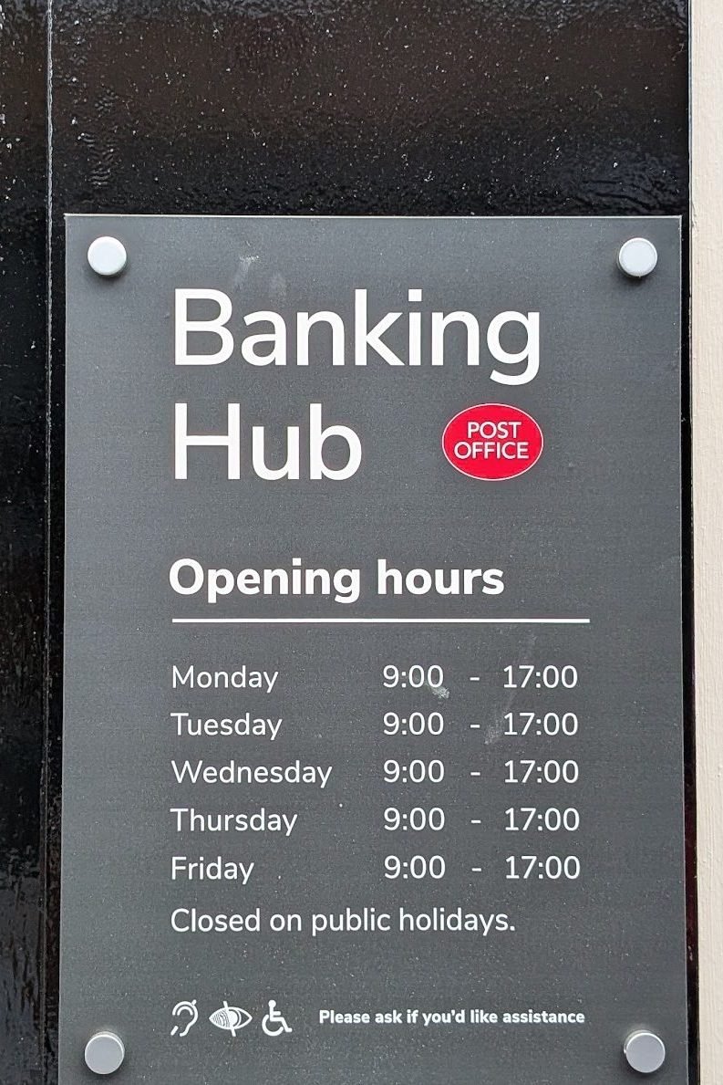 Sign for Banking Hub showing opening hours: Monday to Friday, 9:00 to 17:00, closed on public holidays.